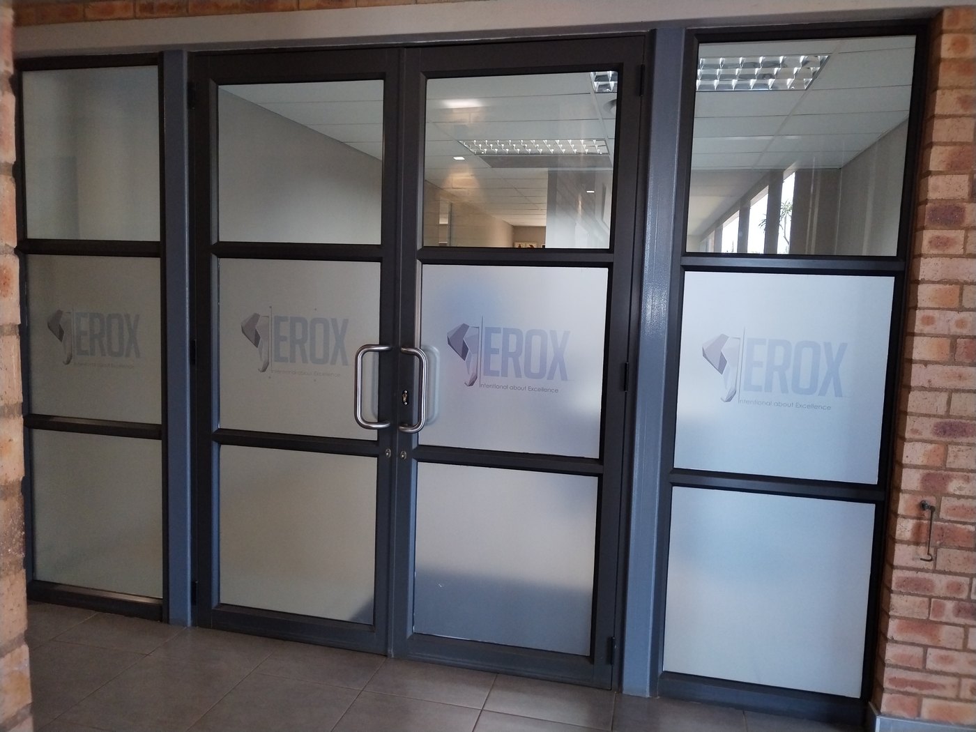 Architectural frosted sandblast glass window graphics on entrance doors for Erox